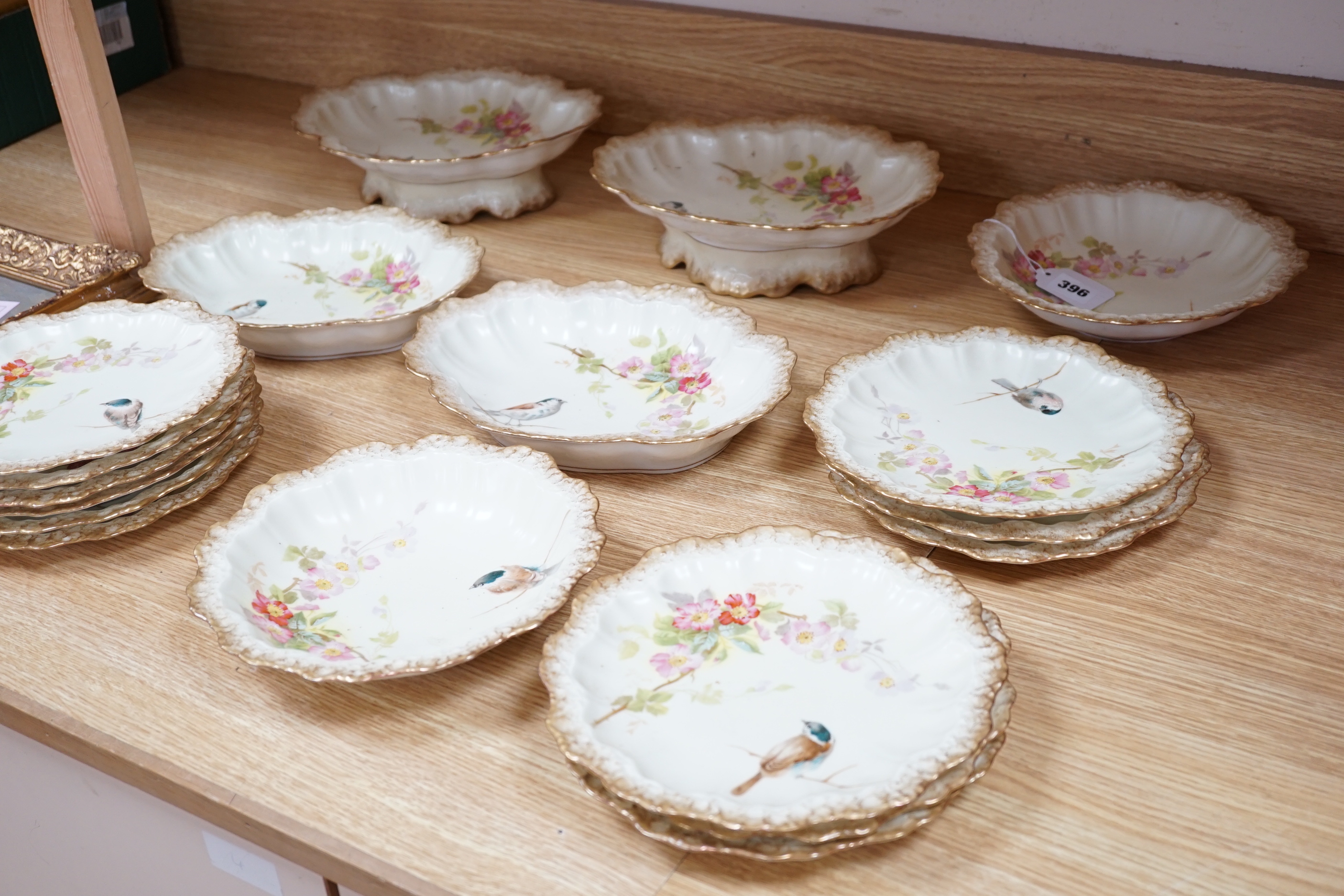 A Limoges dessert service decorated with birds and flowers, the largest 27cm wide